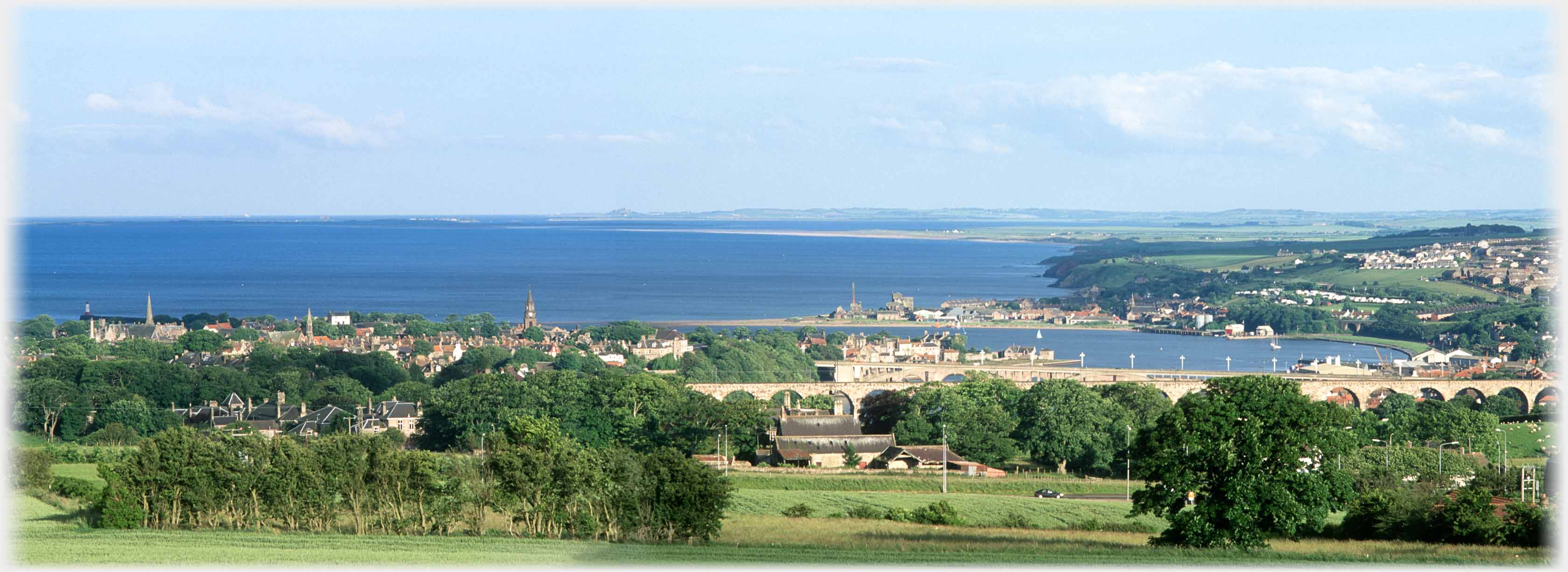Panaramic view of Berwick on Tweed and Sittal with sea and distant Bamburgh Castle.
