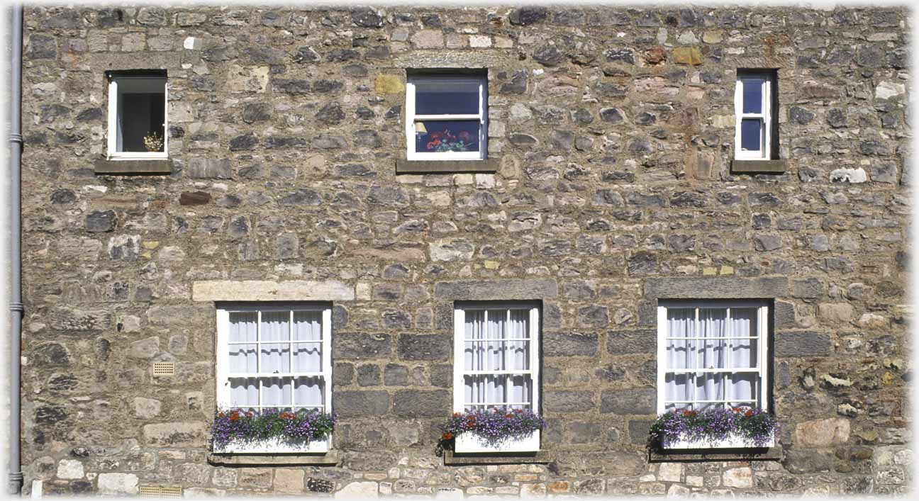 Stone wall with two rows of varigated windows.