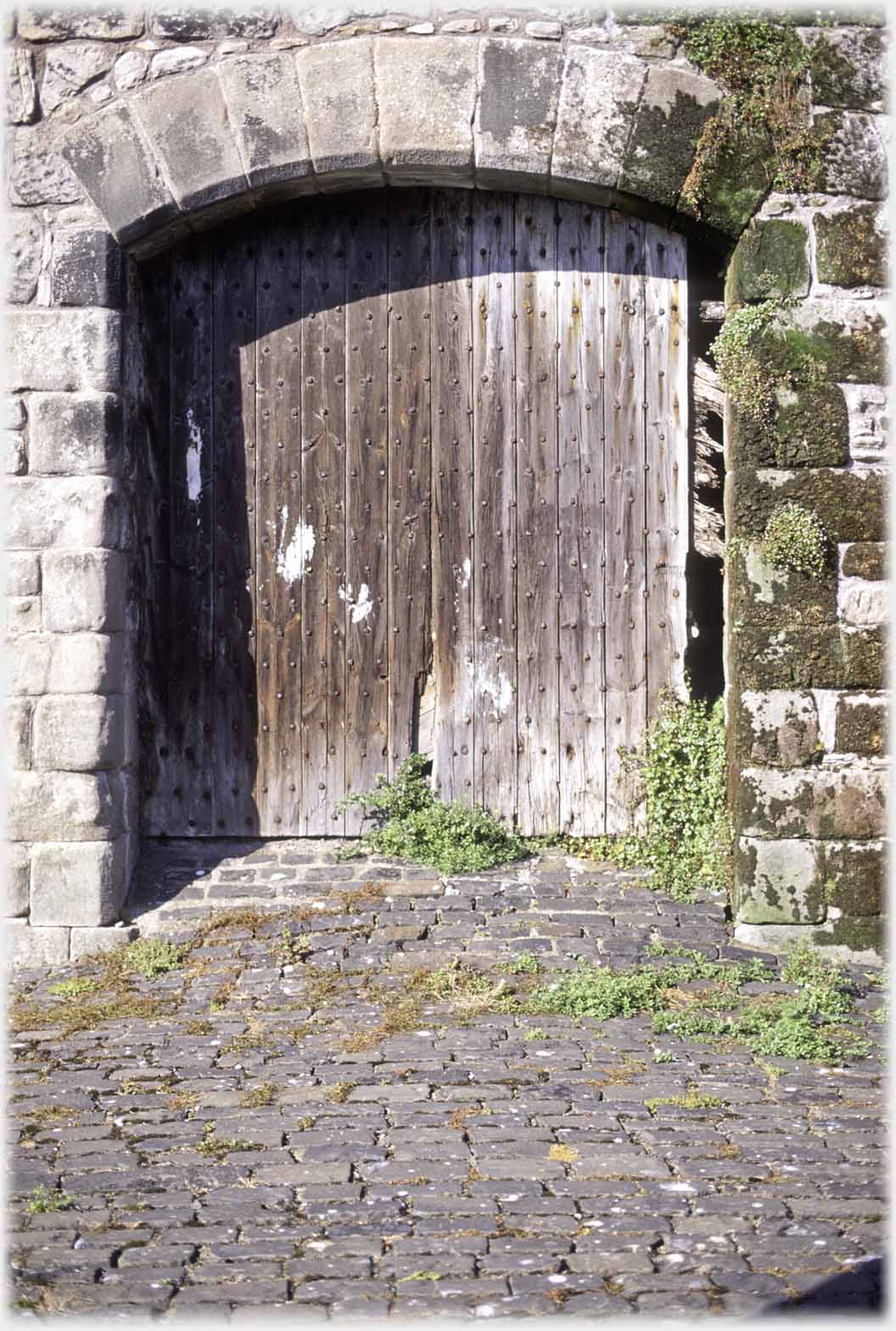 A wider door through wall with an arch of nine stones.