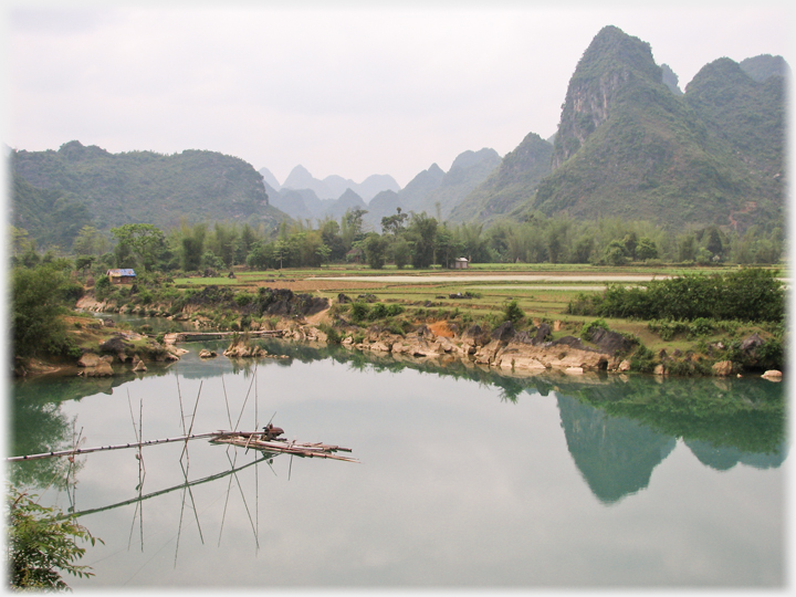 A water pump on a river with a karst background.