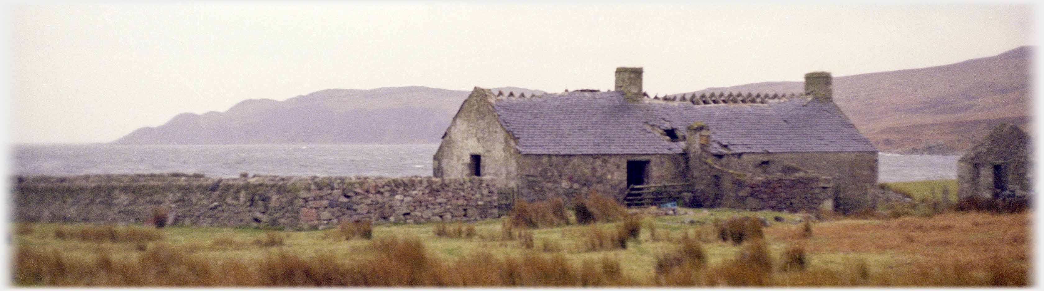 Cottage with chimnies and much of roof intact, but ridge slates missing.
