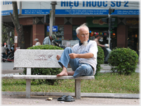Man on bench holding imaginary paper.