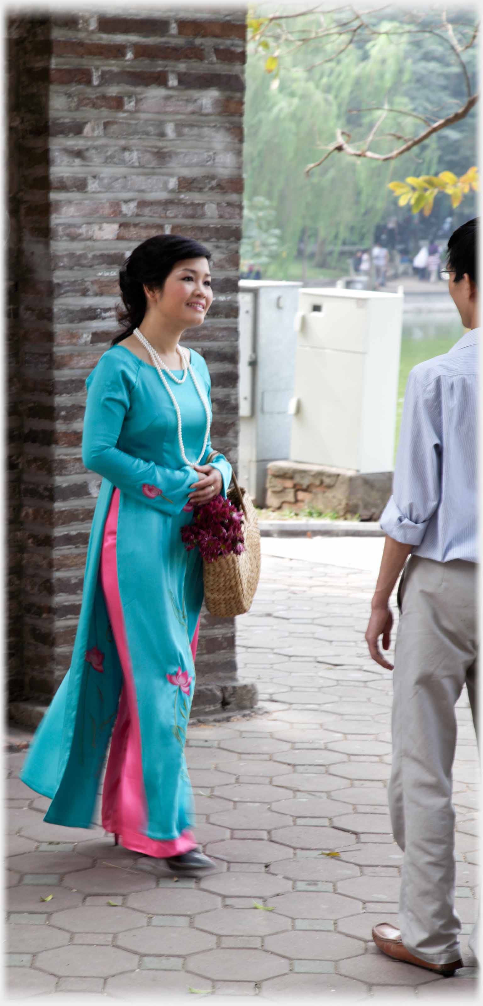 Woman in long elegant turquoise dress standing next to man.