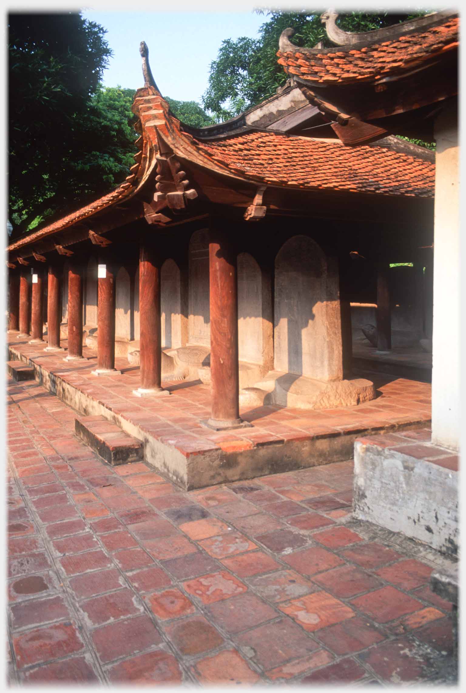 Looking along pavilion with  wooden pillars and stelae.