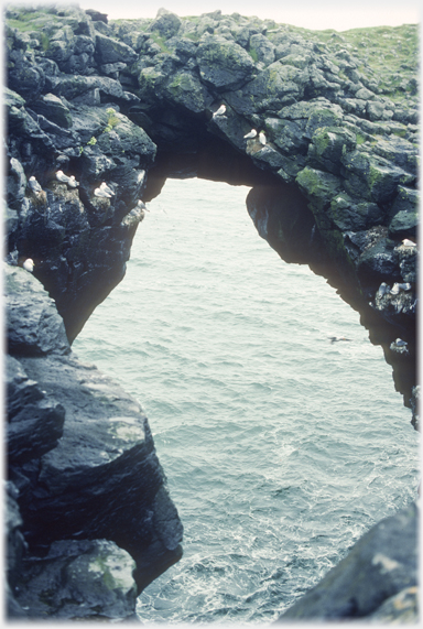 Arch looking through to the sea, diver at right.