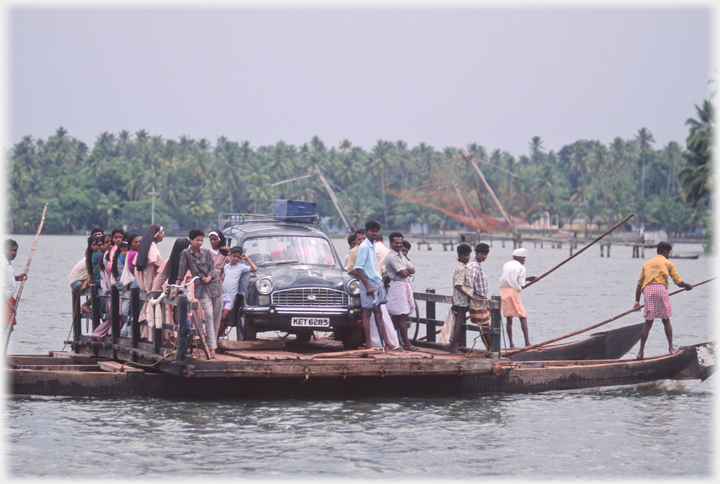 Car and passengers on punted ferry.