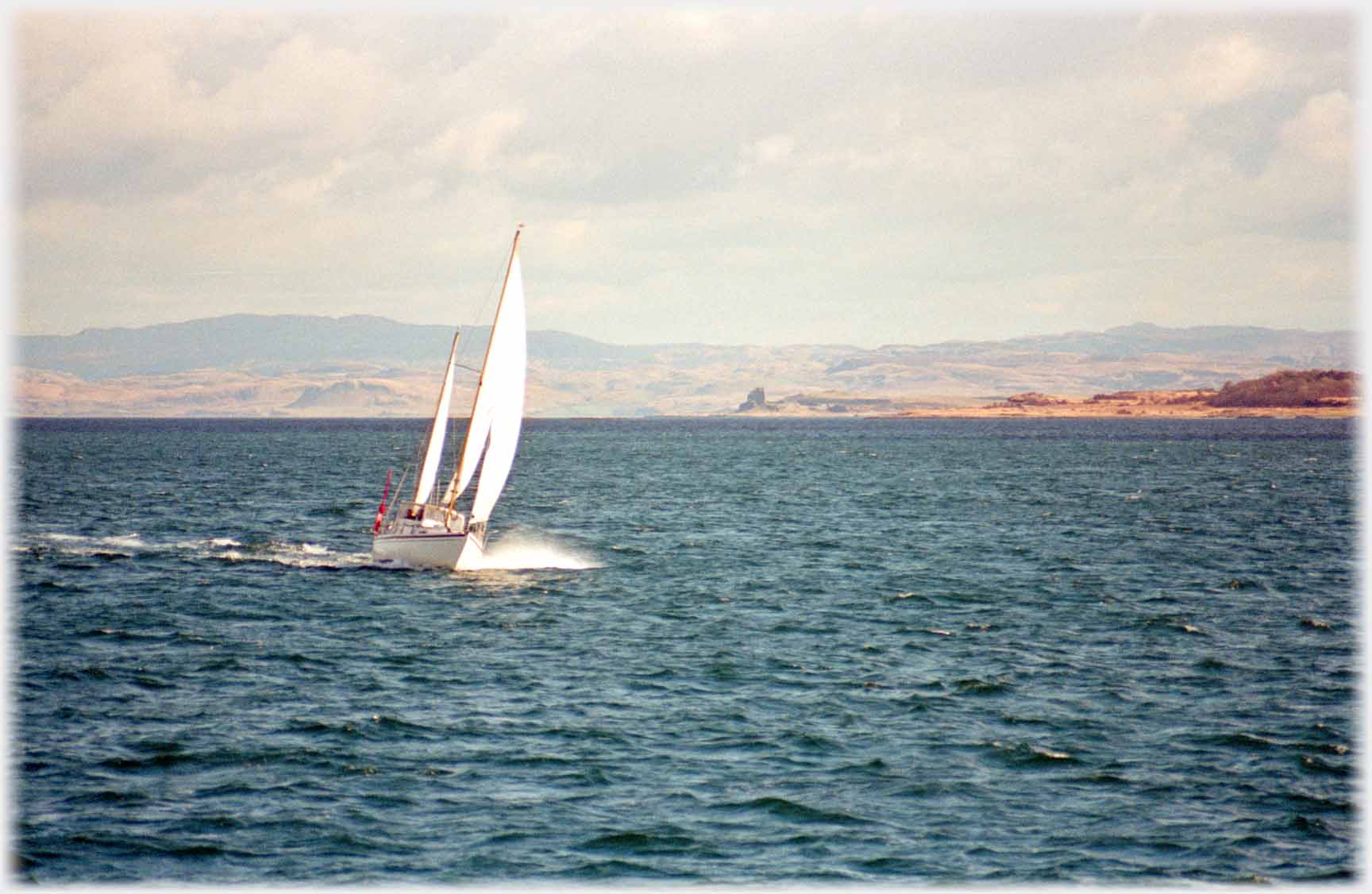 Yacht tilted by wind as it sails.
