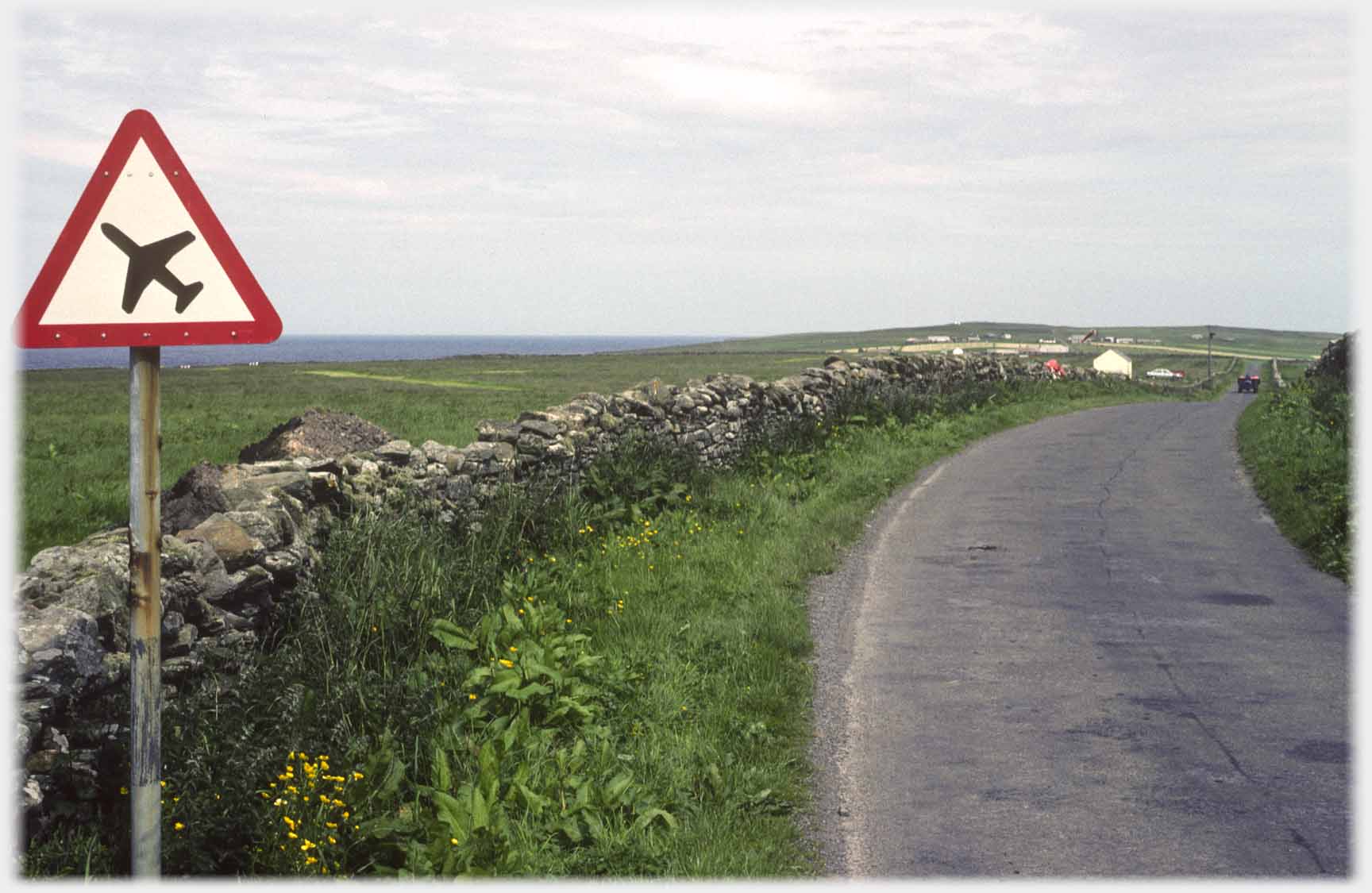 Road with tringular road warning sign of plane.