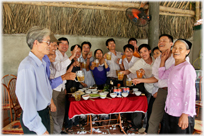 Semi-circle group of people enthusiastically holding glasses up in a toast.