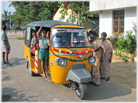 Auto with children in it and women standing.