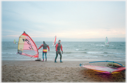 Two wind-surfers on beach.
