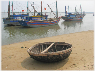 Beached coracle and fishing boats