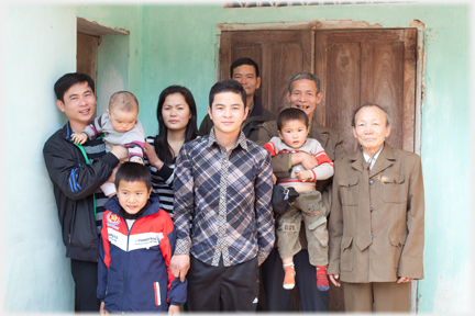 A family arranges itself at the front door for an orderly photograph.