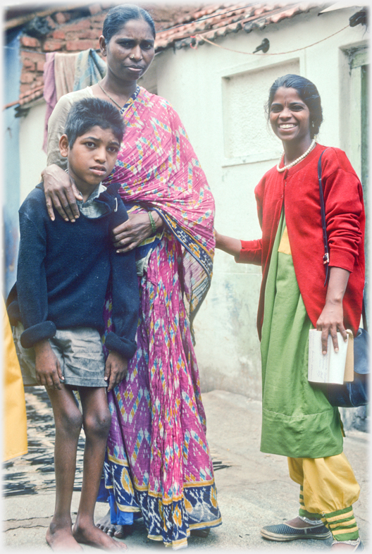 Health worker standing with mother and son.