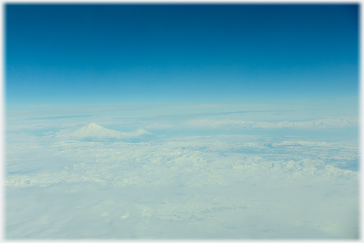 The view from a plane across eastern Turkey, covered in snow, with a distant Mount Ararat.
