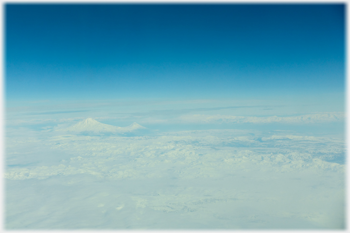 The view from a plane across eastern Turkey, covered in snow, with a distant Mount Ararat.