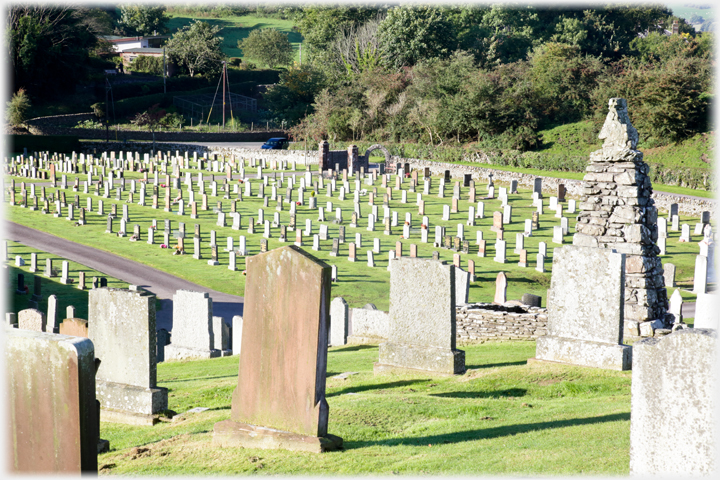 Cemetary with neat lines of headstones.