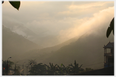 View from hilltop in snow over clouds to far hill.