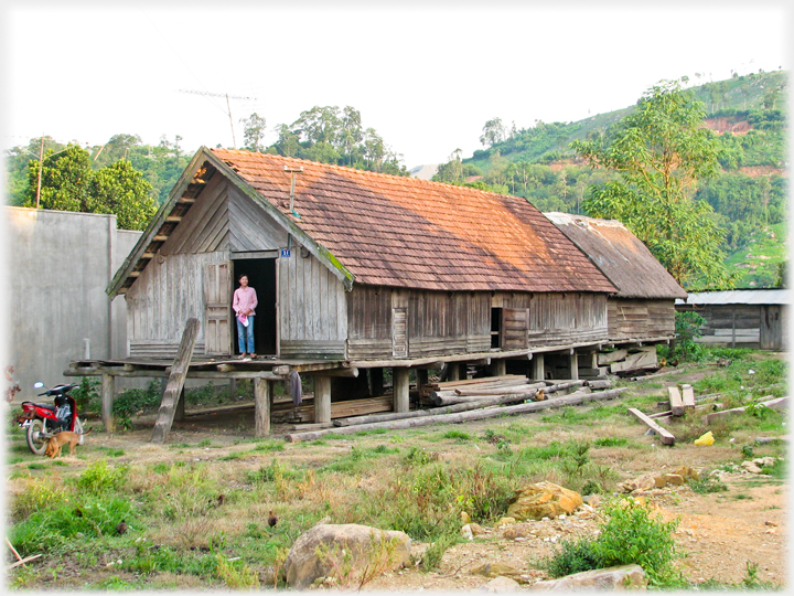 Woman standing on porch platform at end of Long House.