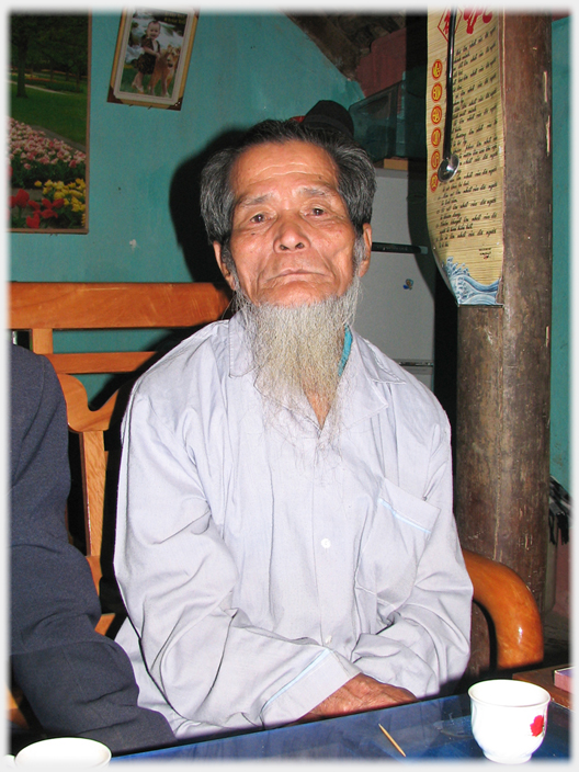 Man sitting at table looking straight into the camera.