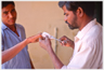 Physiotherapist cutting plaster from man's hand.