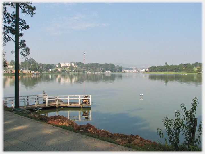 Lake with fisherman on small pier.