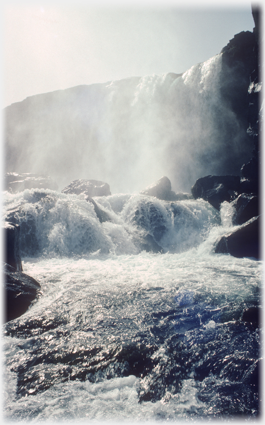 River cascading over cliffs, air filled with spray.