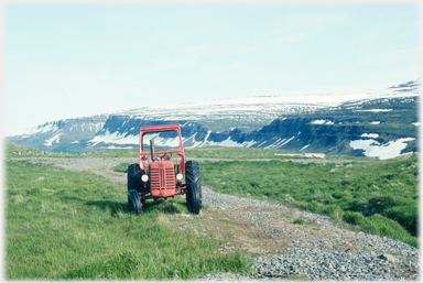 Tractor with mountains behind.