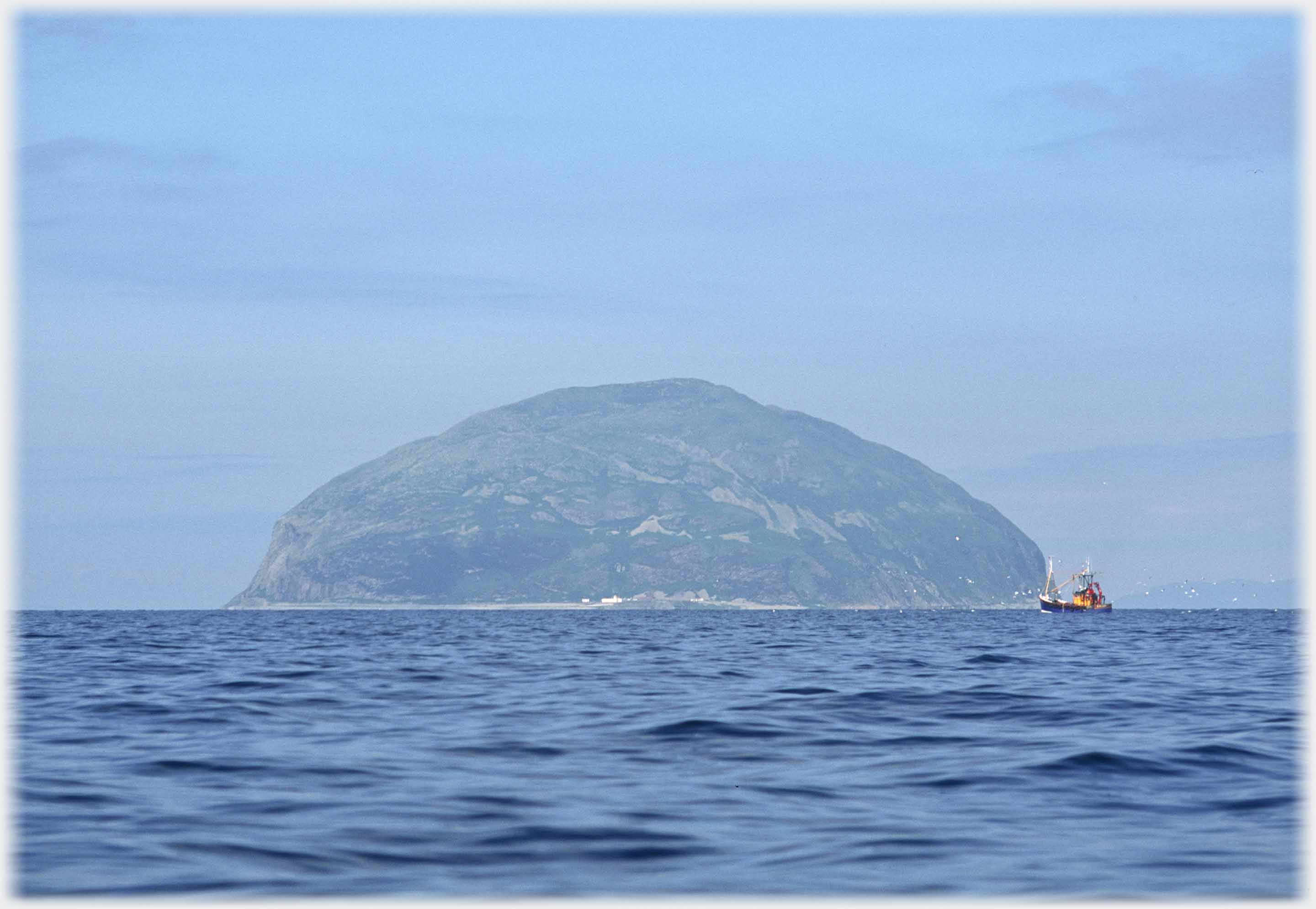 Large humped island with fishing boat.