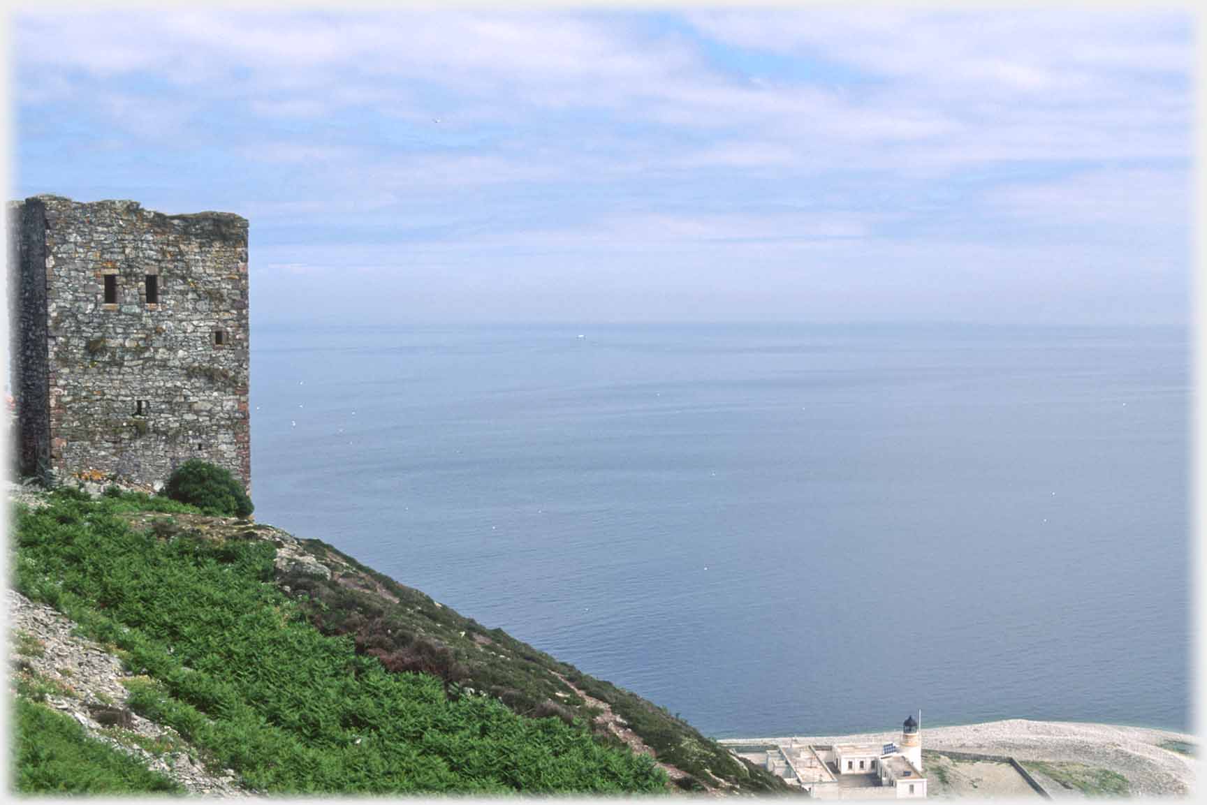 Tower house looking out to sea, lighthoue visible below.