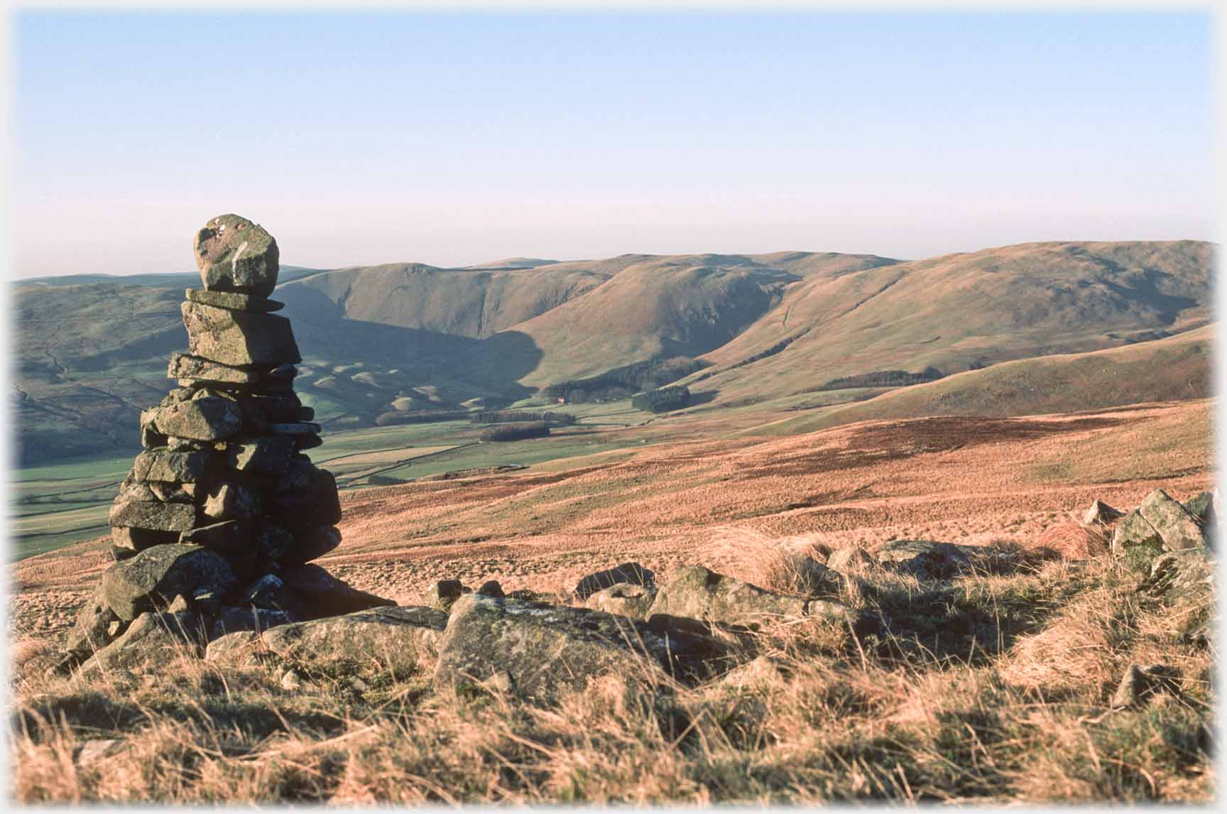 Precarious cairn with hills beyond.