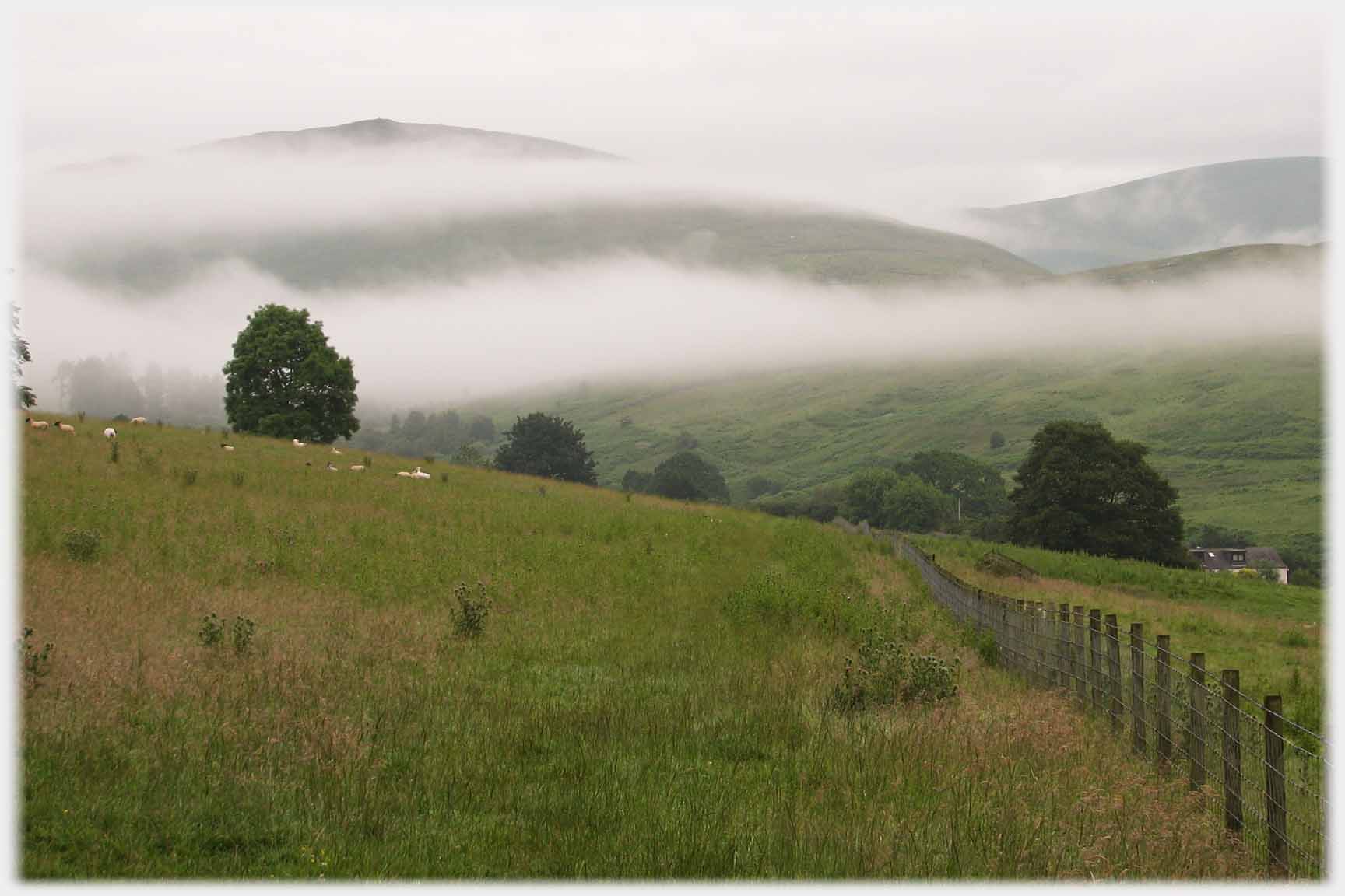 Hill with two layers of cloud in front of it.
