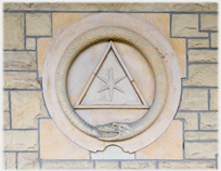 Stone wall plaque of serpant eating its tail.