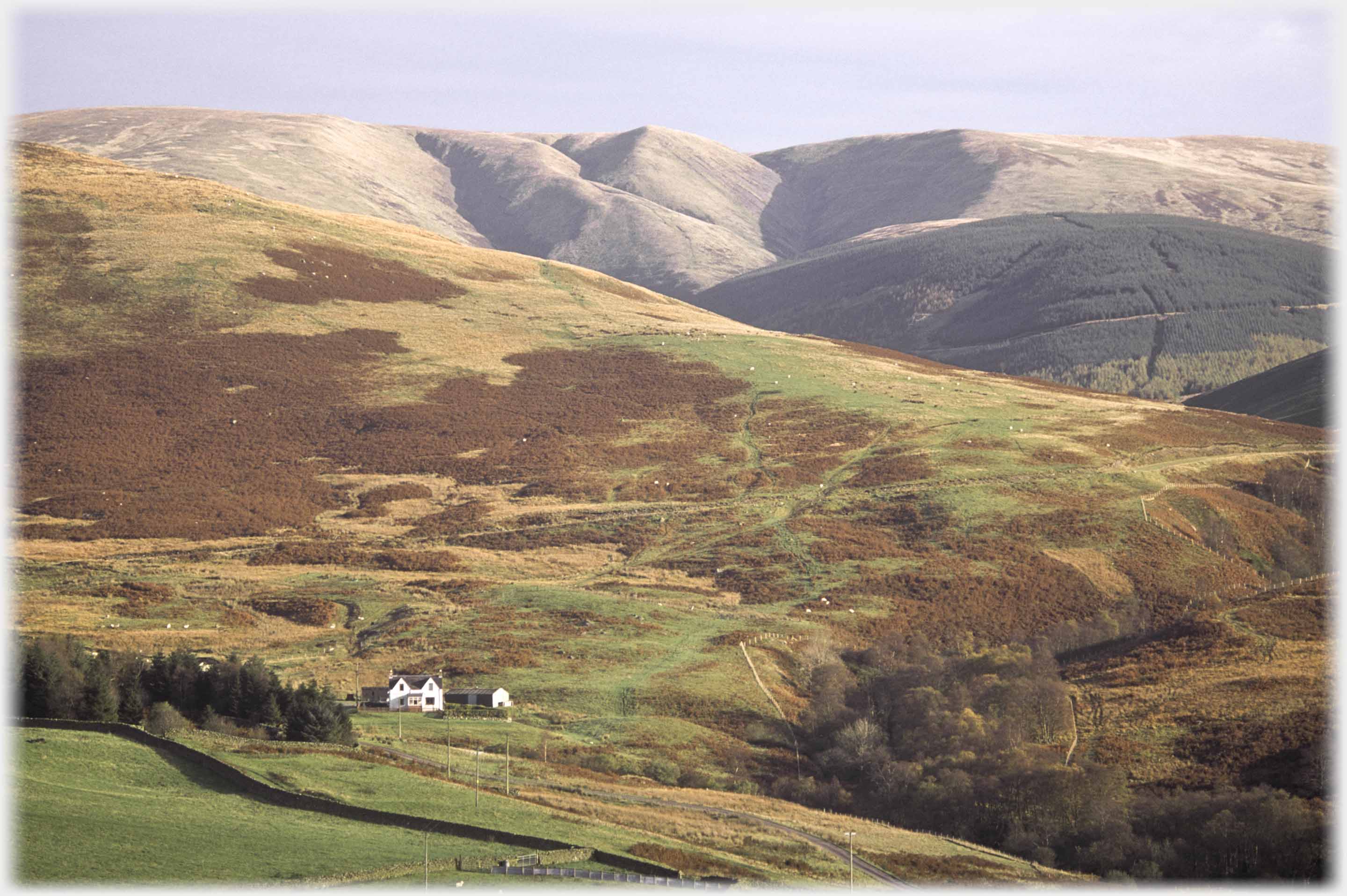 The bulk of the hill emphasised by a longer lens with farmhouse in foreground.