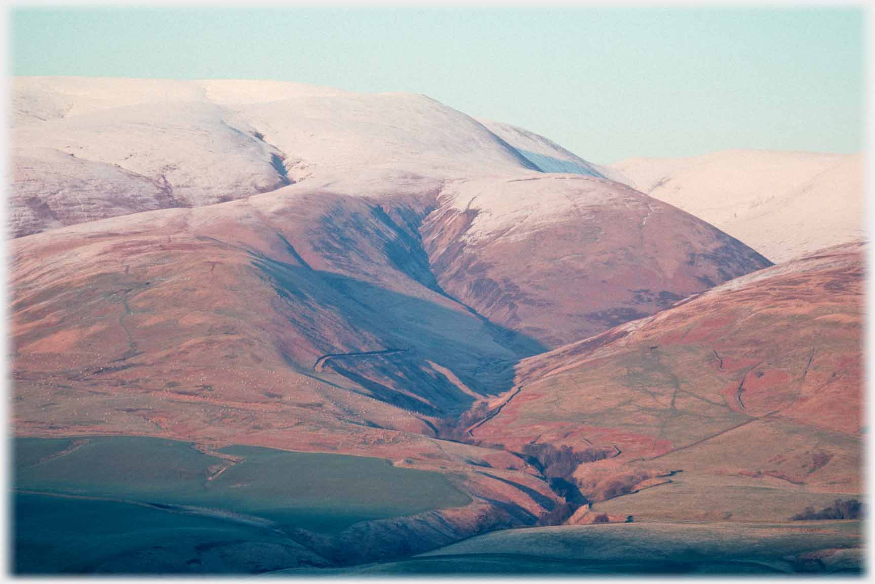 Sasme deep cleft but showing how it sits under the main hill in sunset with snow on top.