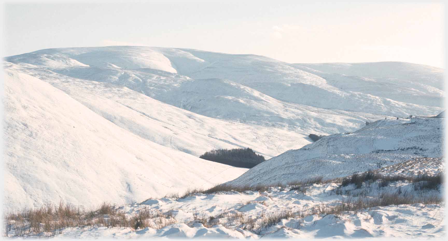 A view from a more northerly angle of a snow covered hill range.