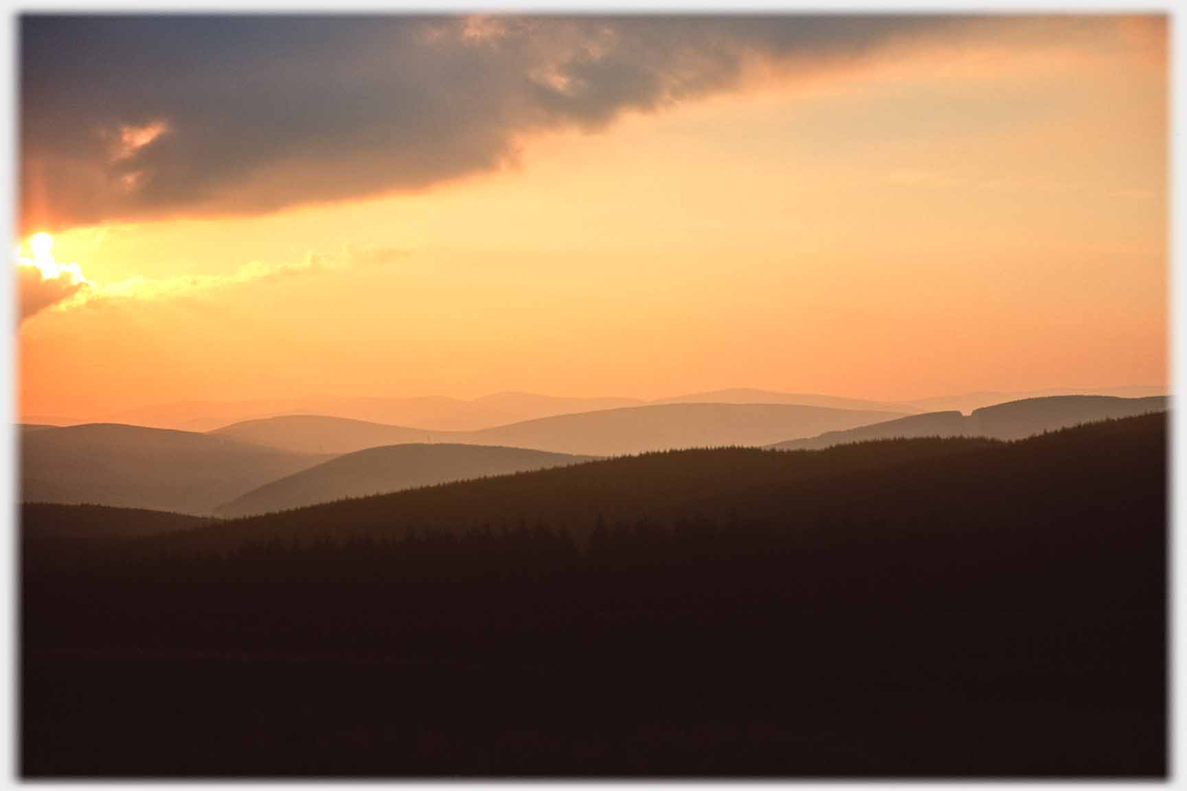 Golden sunlight on low far hills.