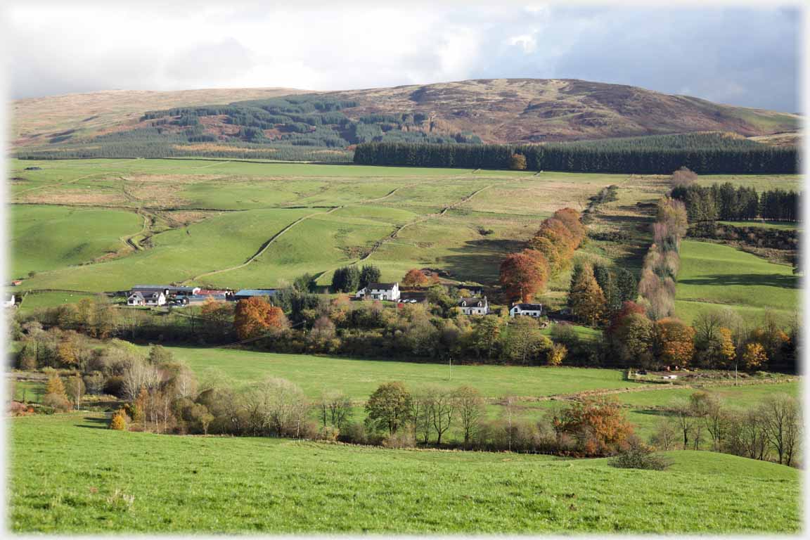 Treed valley side below hill.