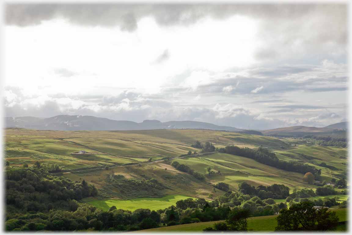 Bright patch of sunlight through clouds liting valley.