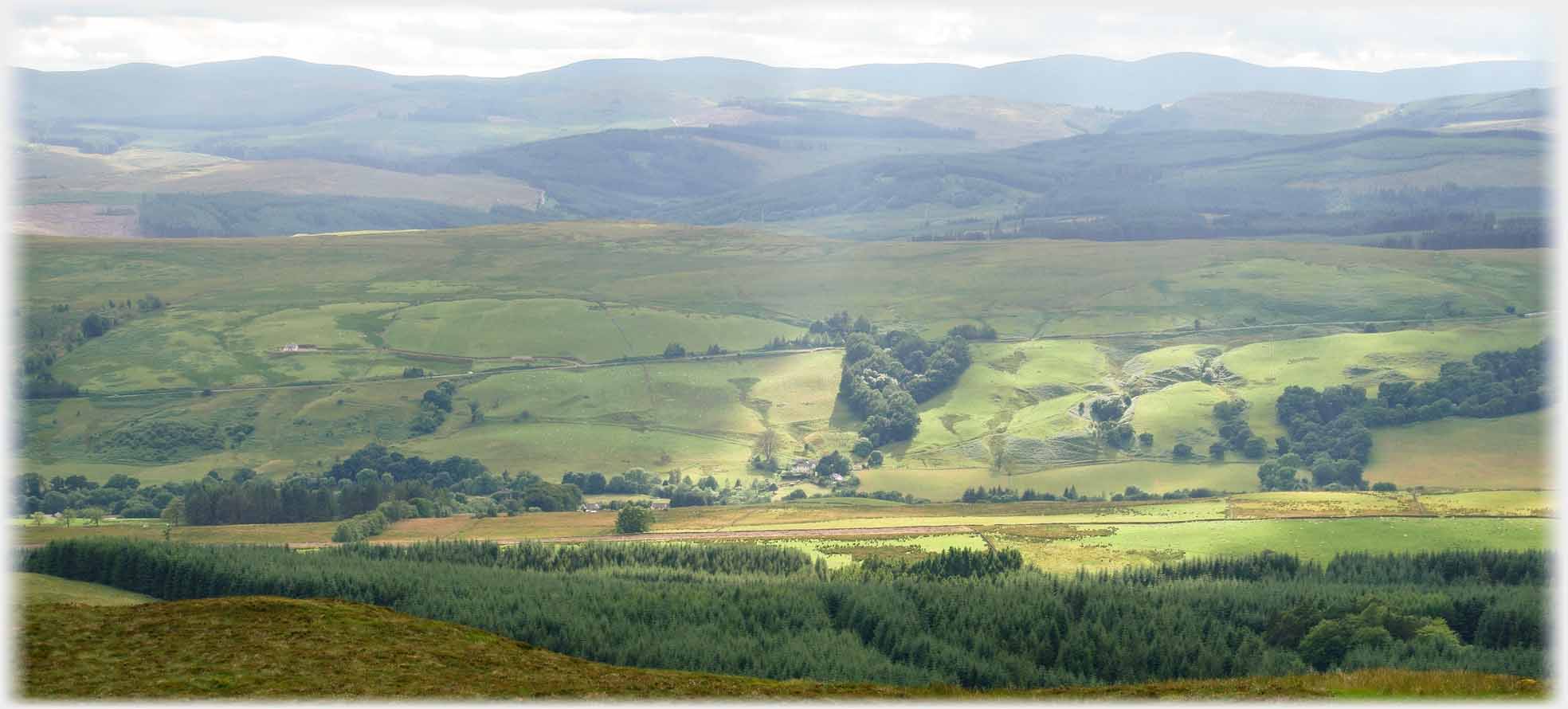 Patch of sun on undulating valley side.
