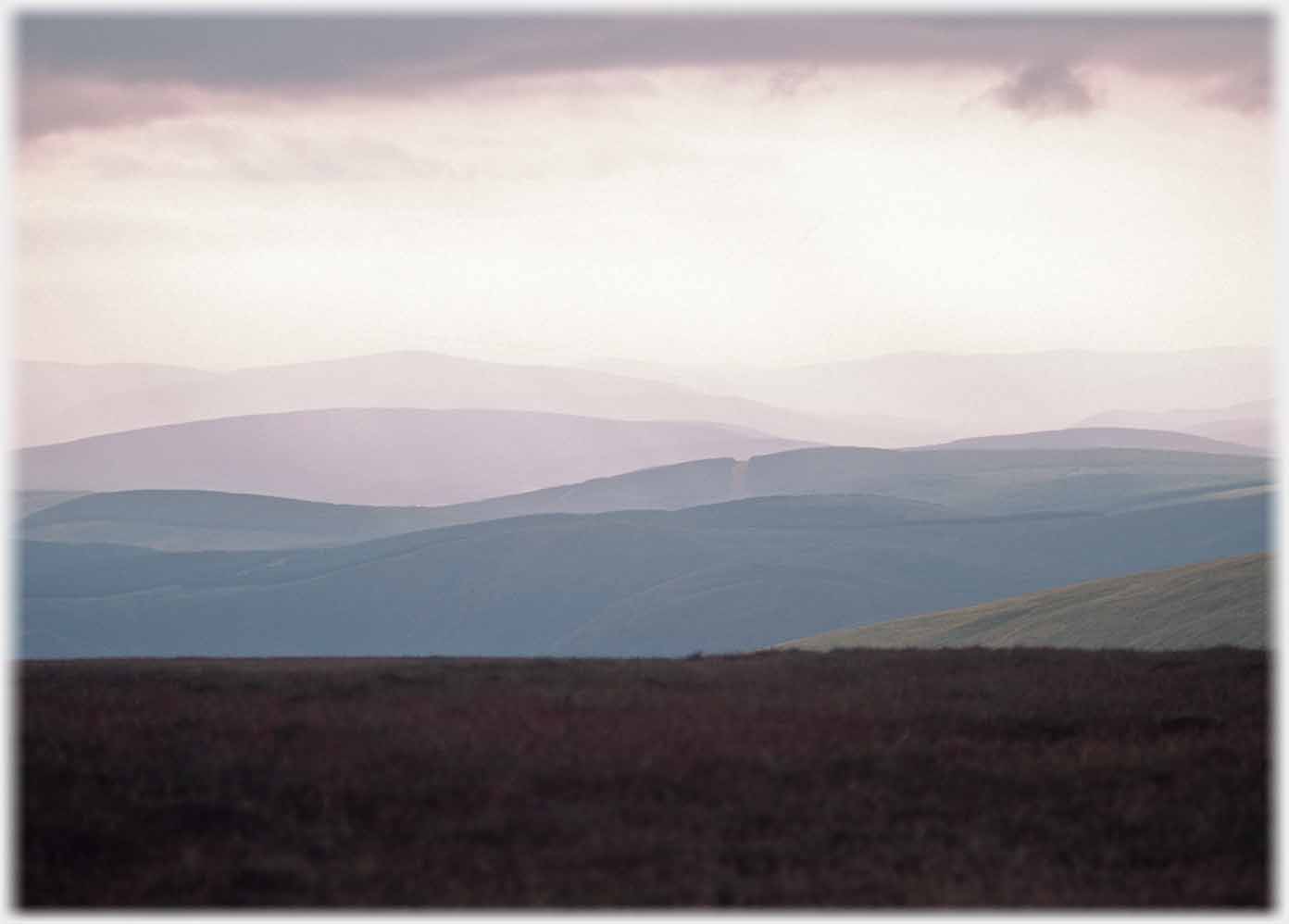 Receding waves of hills in evening light.