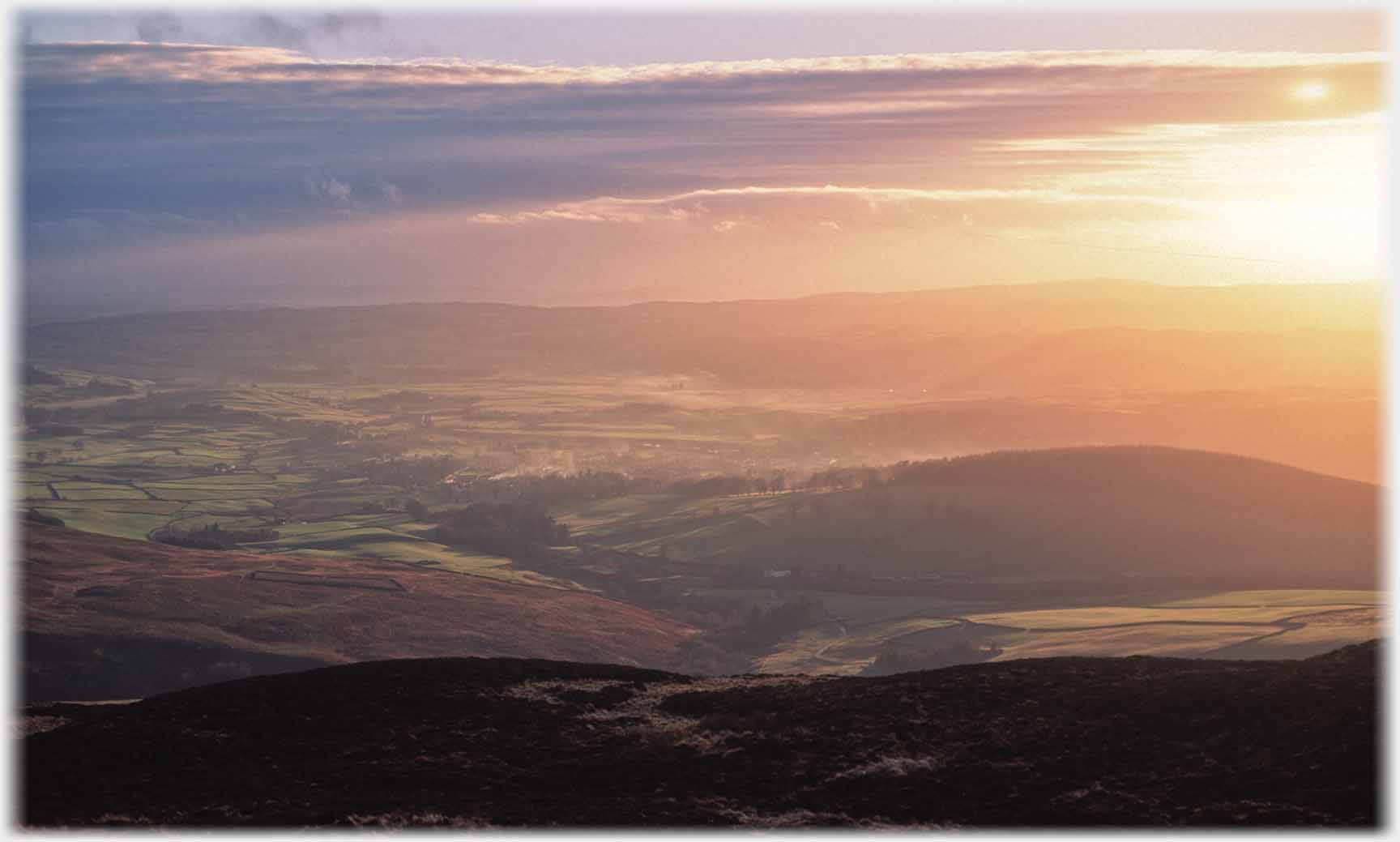 Setting sun over wide valley.