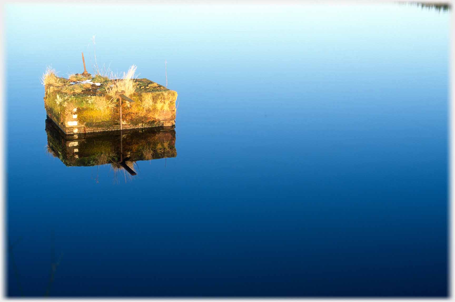 A block in still deep-blue water.