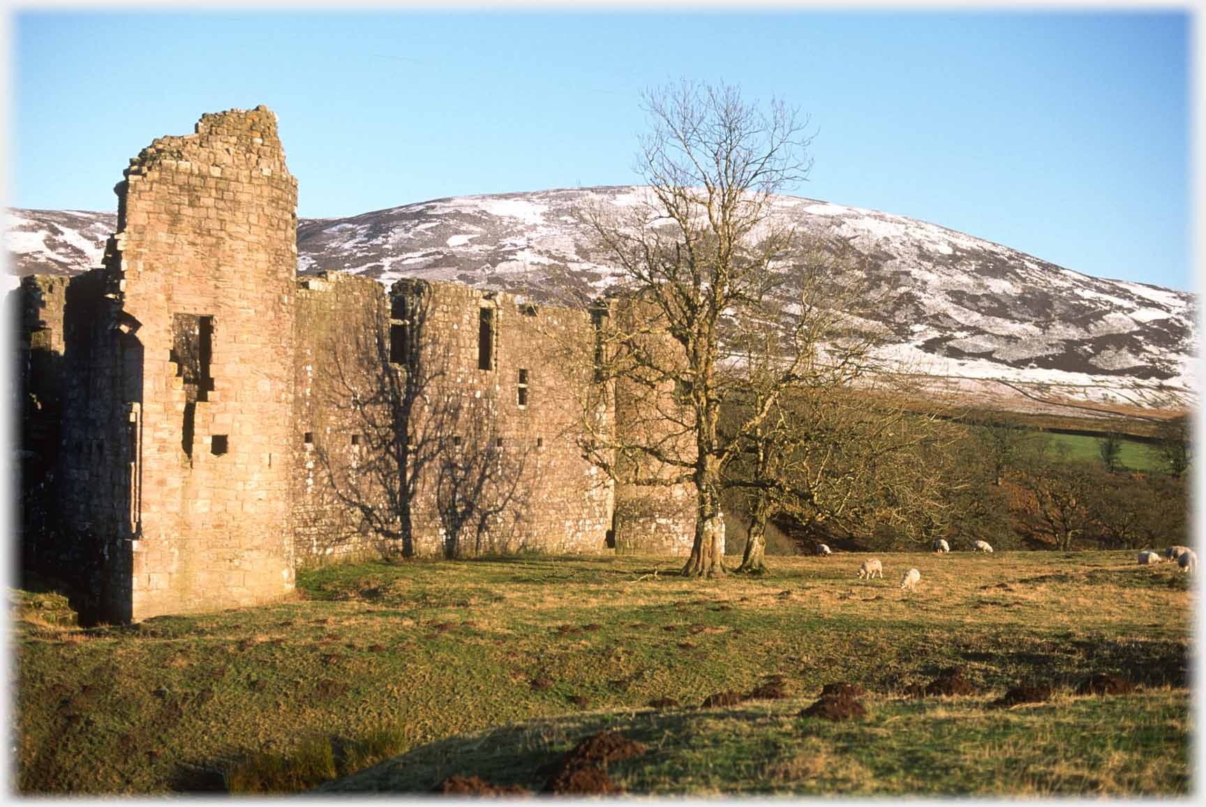 Ruined castle with snowed hills beyond.