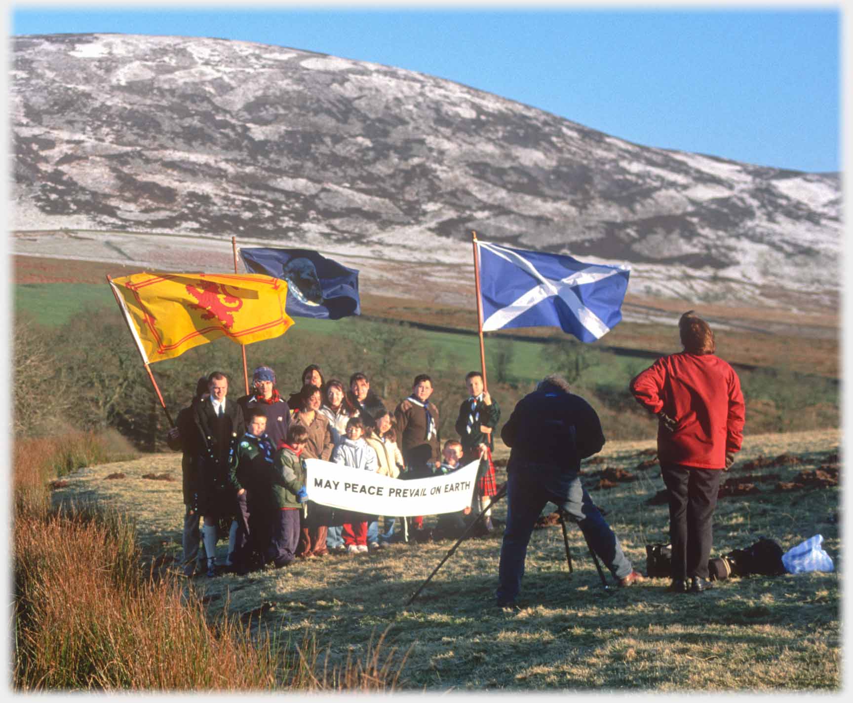 Small group of people with flags being photographed.
