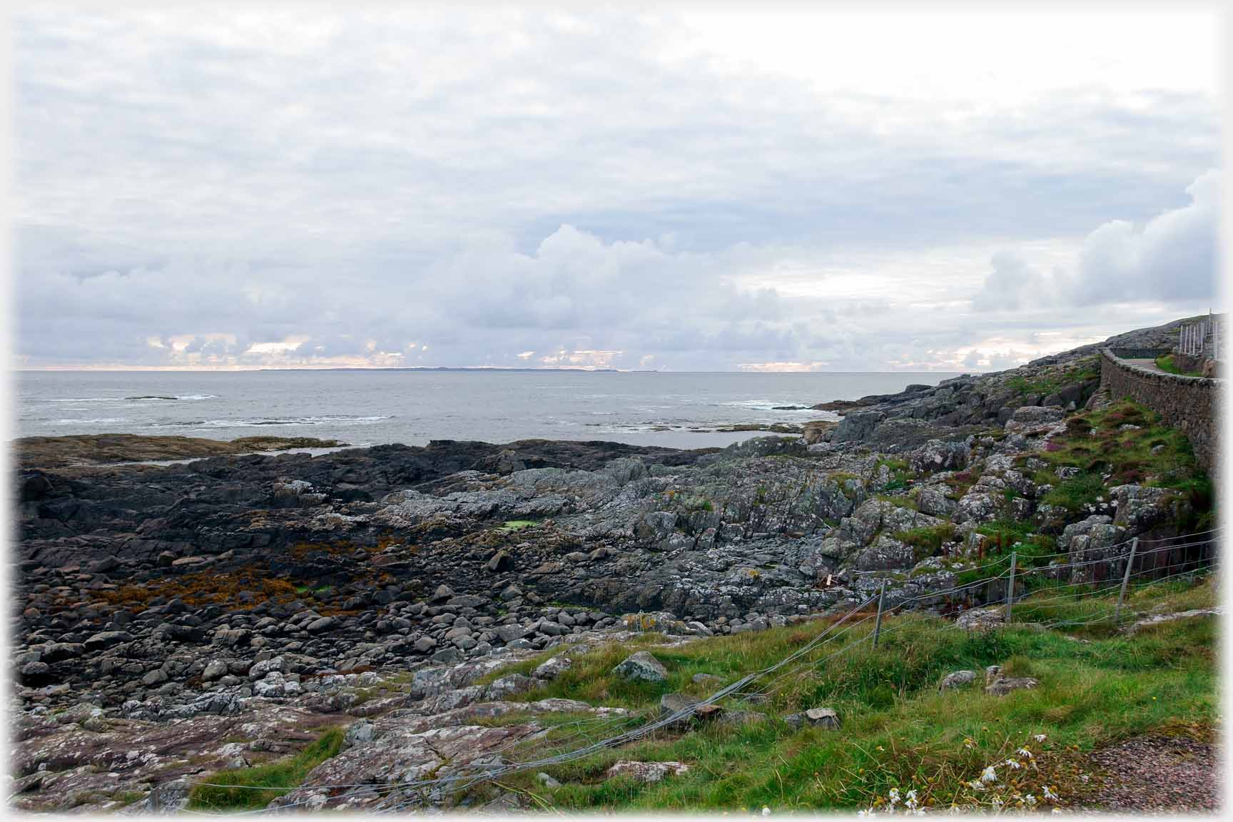 Rocks, sea and slip of land.