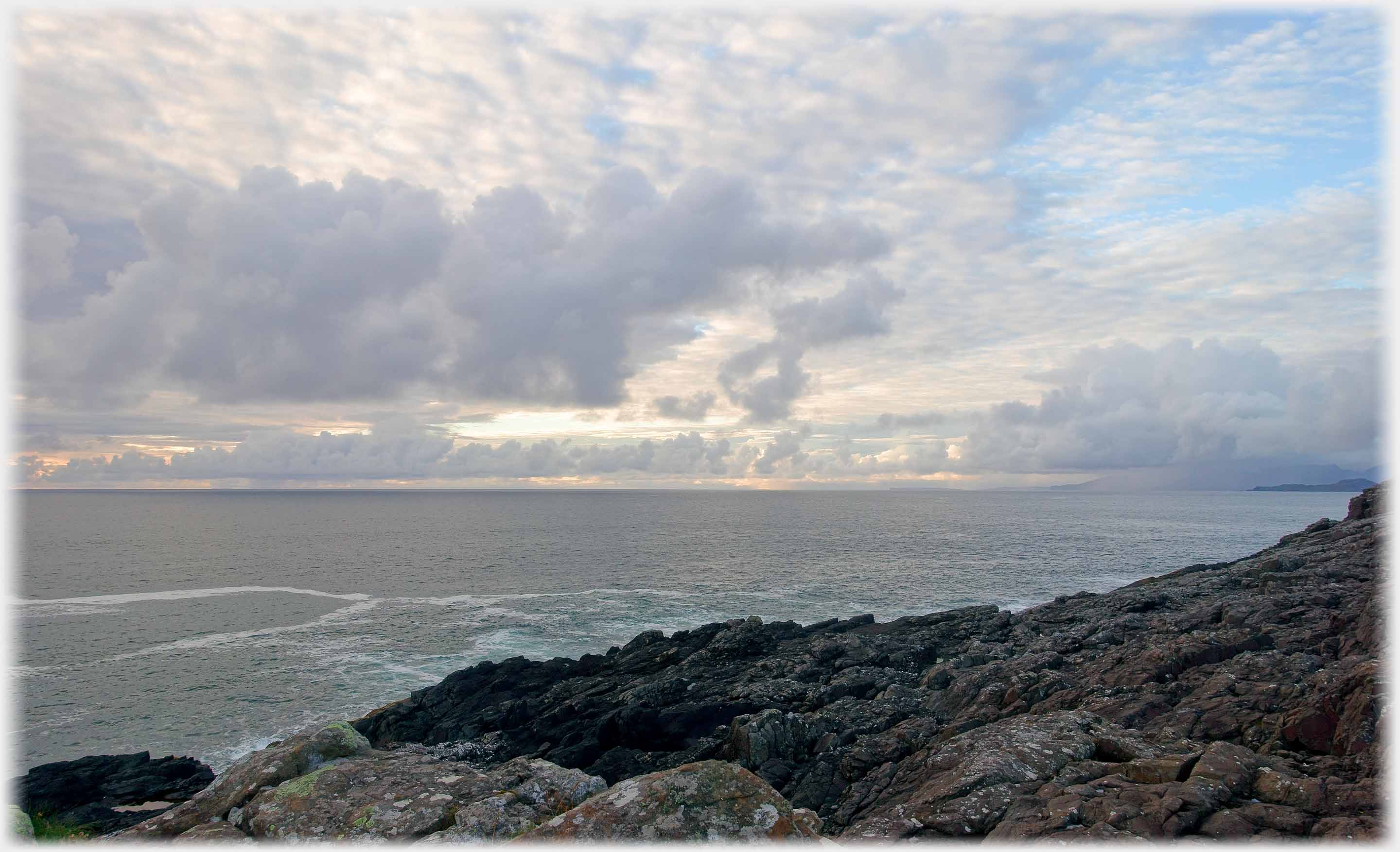 Rocks, sea, and more complex clouds.