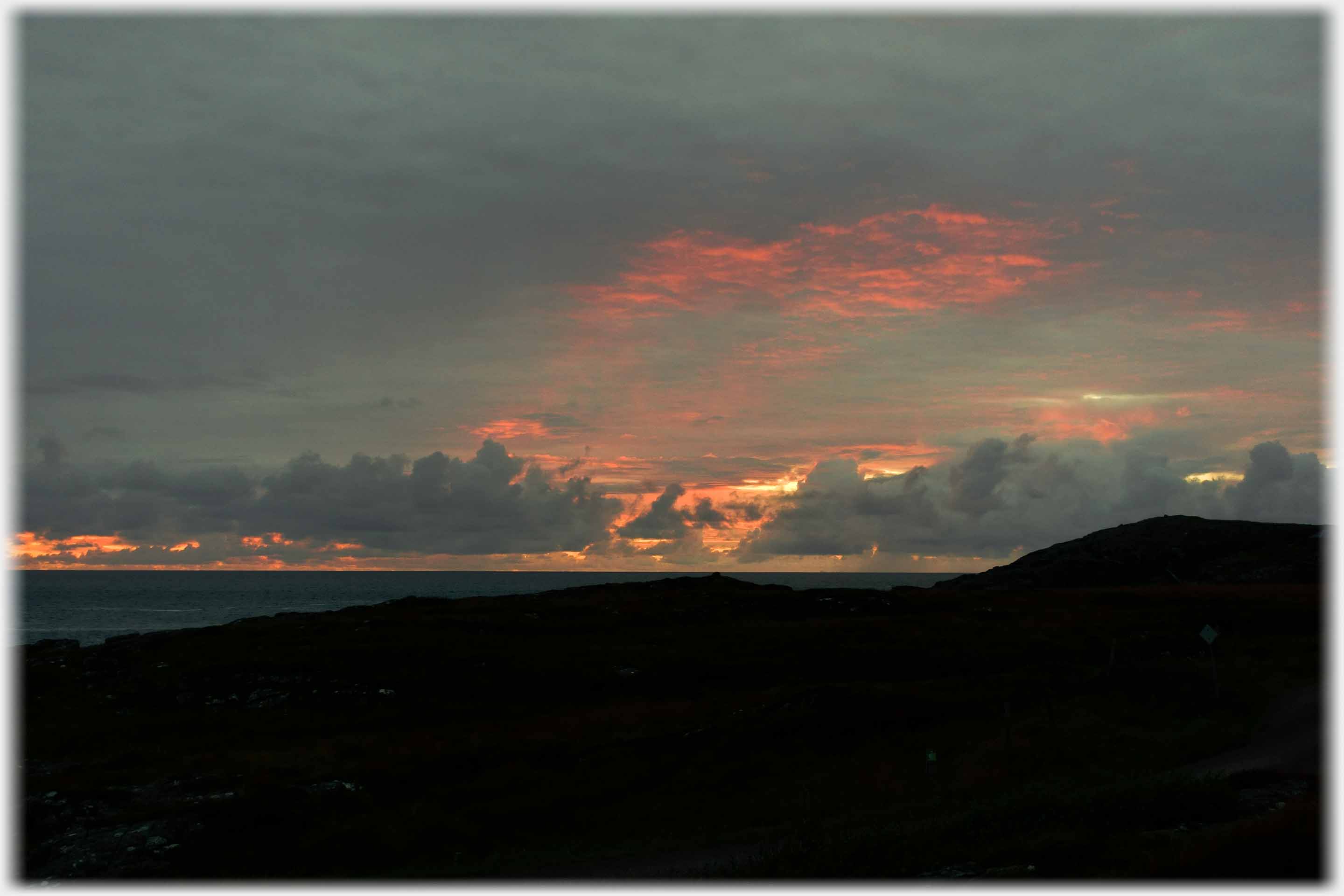 Black foreground with deep colour on clouds.