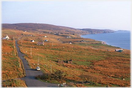 Ground sloping to sea with scattered houses.