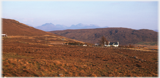 Moorland with house and distant hills.